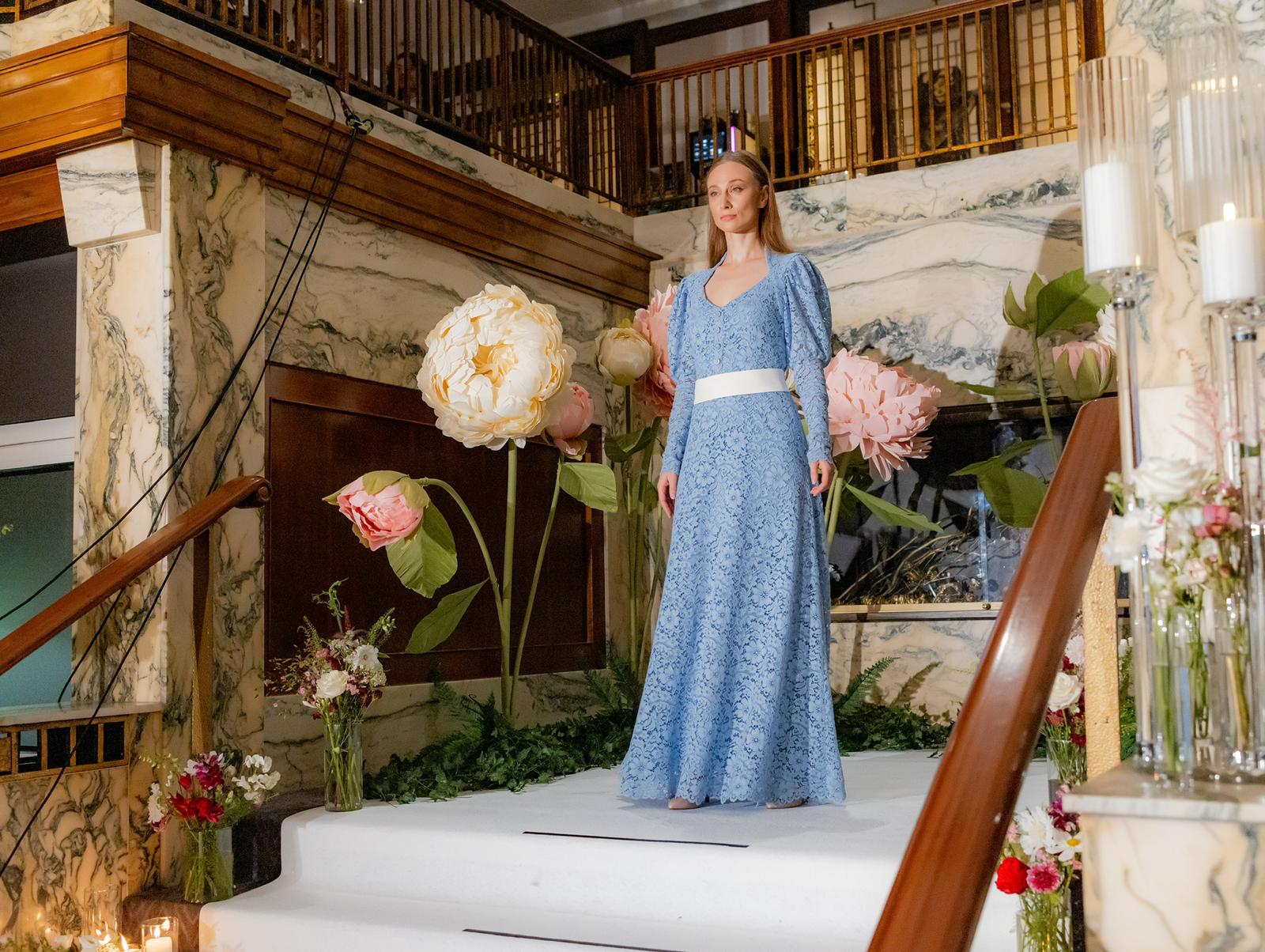 Model posing on runway in a blue dress made by atelier dreisieben, schneiderei Hamburg