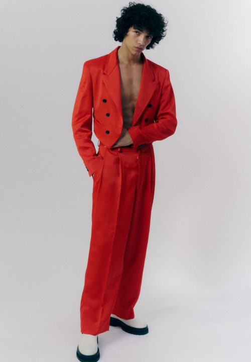Model in a deep red suit, posing in a white studio, Scheiderei Hamburg, atelier dreisieben