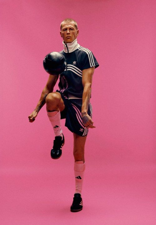 Model dressed in a Adidas x huni outfit dribbling a ball in front of a pink wall, fashion, atelier dreisieben Hamburg schneiderei, maßanfertigung